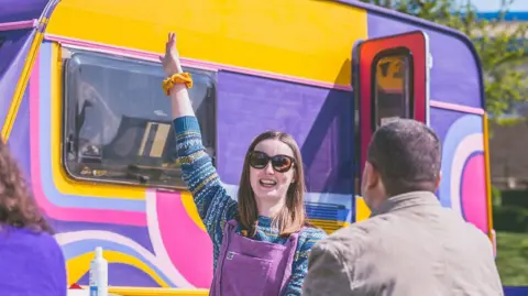 Pride in Tees Valley  A woman outside a colourful caravan 