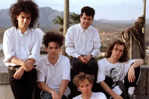 Getty Images The Cure in 1987, sporting the trademark big hair still donned by Smith today