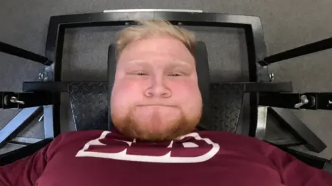 A top-down image of Ray Bowring lying training on a bench press