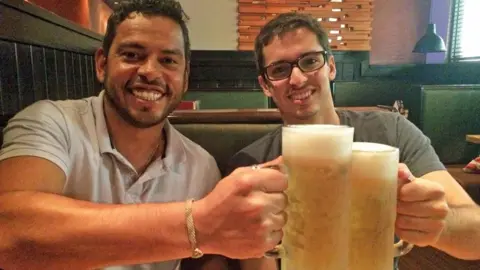 Brazilian police officers Daniel Guerra (left) and Rodrigo Dantas (right) hold beer in 2017