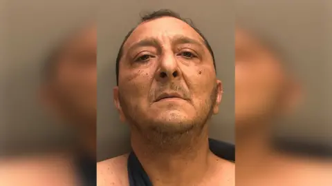Lincolnshire Police A police custody picture of a man with short black hair. He is wearing a black vest.