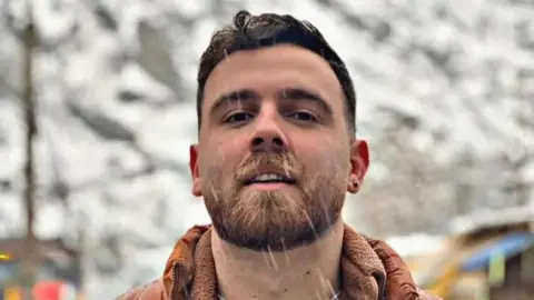 Image of Erfan Soltani, he has a beard and short brown hair. 