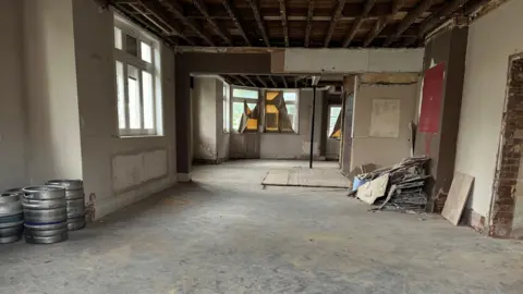 Jaimielee Rendall/BBC An abandoned room inside a former pub building. 