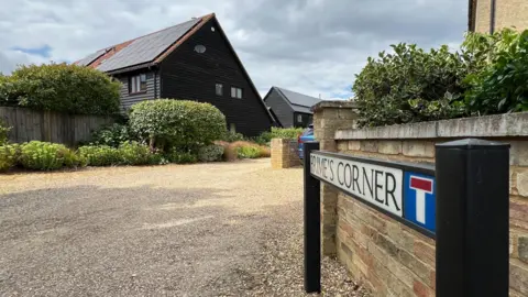 Steve Hubbard/BBC Houses and a Prime's Corner street sign