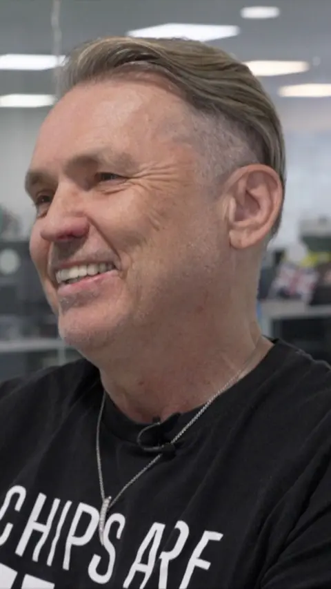 Man smiling looking slightly off to the side of the camera.
