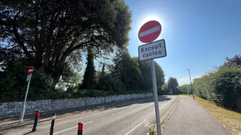 Dryden Road with bollards on the road and red and white no entry signs