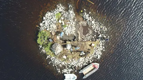 An artificial island built from large white stones in a Scottish loch - captured from above
