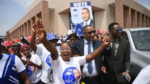 AFP A smiling UDC supporter holds his hands in the air as he greets party leader Duma Boko.