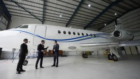 US Secretary of State Marco Rubio listens to Edwin F. Lopez, the attache for DHS Homeland Security Investigations, next to the Venezuelan government airplane that Rubio announced is being seized by the U.S. during a news conference at La Isabela International Airport in Santo Domingo, Dominican Republic, Thursday, February 6, 2025