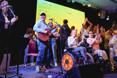 Ed Sheeran performing with young people 