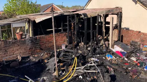 A garden shed and nearby structures at a house in Inby Close, in North Wingfield, Chesterfield, destroyed in a fire.