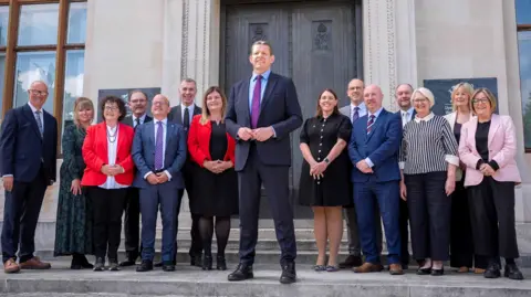 PA Media Rhun ap Iorwerth in the middle flanked by cabinet ministers