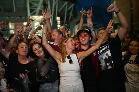 Fans of British rock band Oasis react outside the Principality Stadium in Cardiff on July 4, 2025, after attending the opening concert of their highly anticipated reunion tour nearly 16 years after last performing together.