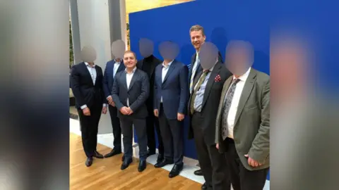 112ua.tv Published on the website of a Ukrainian tv channel (112ua.tv) in February 2019 - the channel has been shut down by Zelensky after the Russian invasion. Third from left is Oleg Voloshyn, named in David Deans' copy and was the man in contact with Nathan Gill before his speeches in the European Parliament. Gill and Voloshyn both wear suits and stand among six other men in suits. 