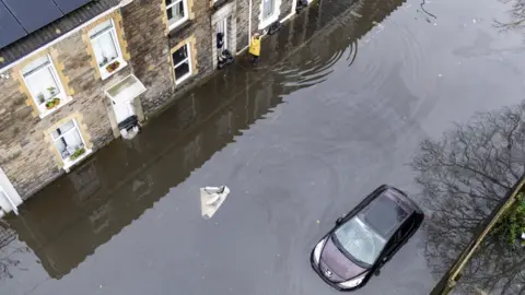 Aerial view of flooding in Briton Ferry, Neath Port Talbot, on Monday, with car flooded in terraced street and road under water