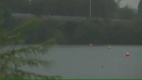 Yellow and pink buoys on Scotsmans Flash lake in the rain