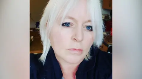 Supplied A head and shoulders selfie-style image of Jacqueline Day. She is wearing a dark top and looking directly into the camera with a smouldering facial expression. 