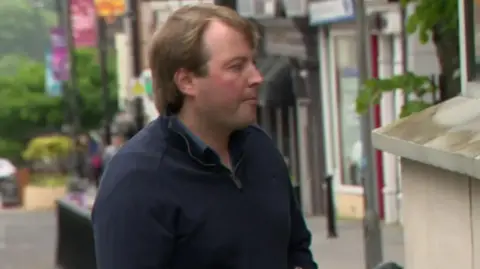 Archive photo of Jonathan Creswell wearing a navy jumper and a dark blue shirt