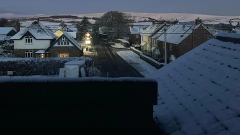 Rooftops of houses seen from above with a layer of snow