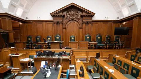 PA The interior of Court one at the Old Bailey, with rows of wood panelled desks