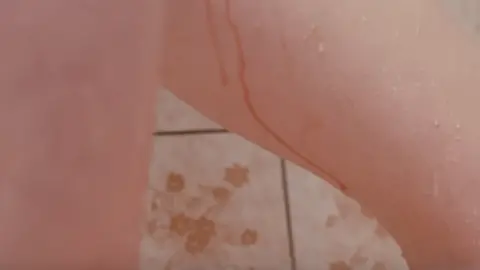 Bodyform Woman in the shower with blood on her thighs