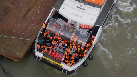 PA Media Drone view of a group of people thought to be migrants arrive onboard a Border Force vessel at the Border Force compound in Ramsgate, Kent.
