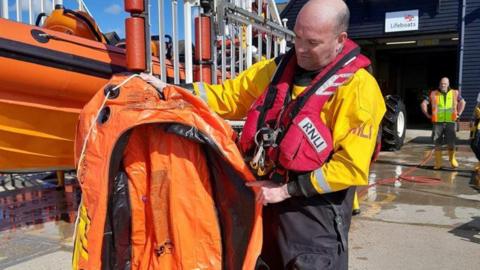 Lifeboat helm Andy Williams with the inflatable dingy a girl, 10, was found adrift in