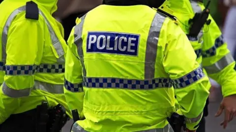 Three police officers in fluorescent uniform jackets