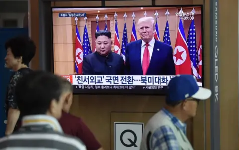 Getty Images People in Seoul watch Trump and Kim