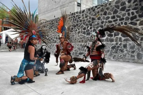 AFP Dancers perform ahead of a pre-Columbian ballgame called "Ulama" -in Nahuatl indigenous language- which rule is to hit a "Ulamaloni" (solid rubber ball) with the hip or shoulder, at the FARO Poniente cultural centre in Mexico City on August 21, 2019