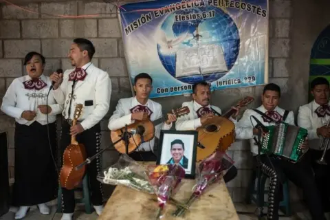 EPA A Christian mariachi sings at the wake of Elfego Roliberto Miranda, one of the 16 Guatemalan migrants who died in Tamaulipas, Mexico, in Comitancillo, Guatemala 13 March 2021