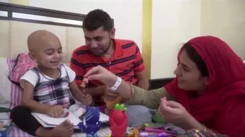 CBS Zainab plays with her mother and father