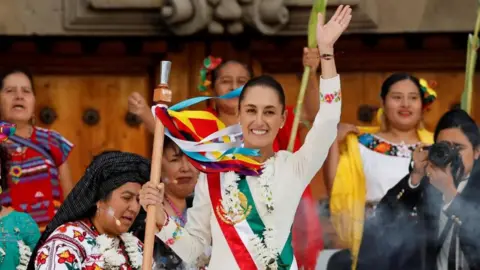 Reuters Presiden baru Meksiko Claudia Sheinbaum memegang jabatan tersebut "tongkat komando" saat upacara di Zocalo Square di Mexico City, Meksiko 1 Oktober 2024.