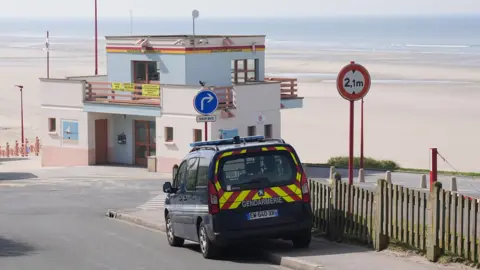 An emergency vehicle which says Gendarmerie on the back, parked up at the beach 