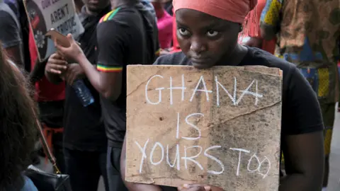Francis Kokoroko/Reuters A demonstrator displays a placard anti-government protests in Accra, Ghana - Saturday 23 September 2023