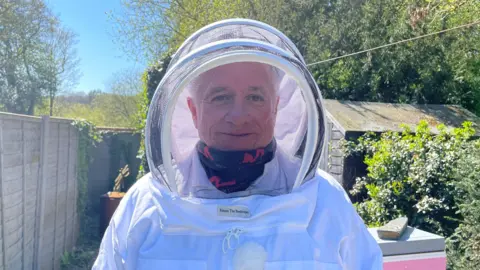 A man in beekeeping gear