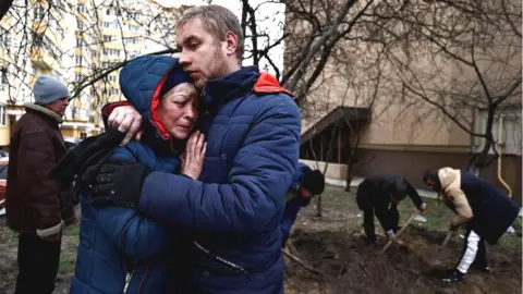 Reuters Residents of Bucha mourning a friend whom they said had been killed by Russian soldiers