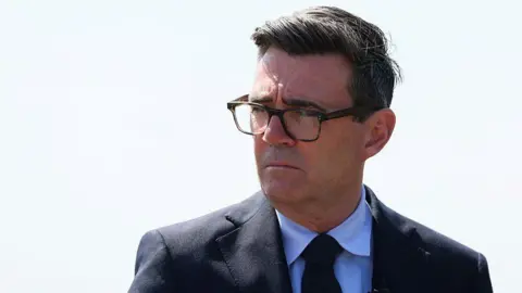 Getty Images Andy Burnham, wearing a blacksuit and black glasses