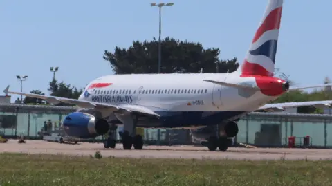 A British Airways plane lands on the runway at Guernsey Airport.