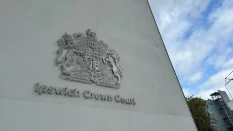 George King/BBC The Ipswich Crown Court logo on a concrete wall