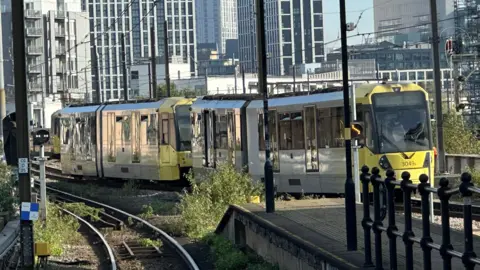 A Metrolink tram slightly off the tracks at Cornbrook stop in Greater Manchester