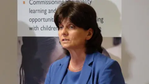 PA Media Joyce Thacker, pictured in a blue dress and jacket, with shoulder length brown hair