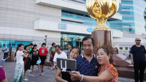 Getty Images Mainland tourists visit the Golden Bauhinia Square in Wan Chai, 2017