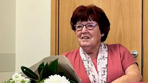 Somerset NHS Foundation Trust Sylvia Parsons with a bouquet of flowers