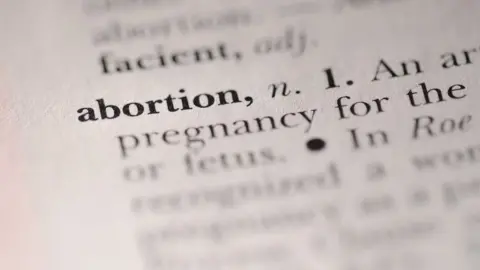 Getty Images The word 'abortion' highlighted in a dictionary