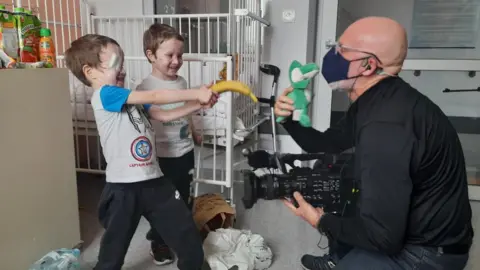 Kasia Madera Nazar and Timur play with camera operator Paul Cooper