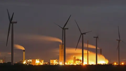 Getty Images Wind farm and chemical plant on River Mersey