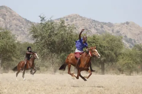 AFP Two men on horseback race through the Sahel.