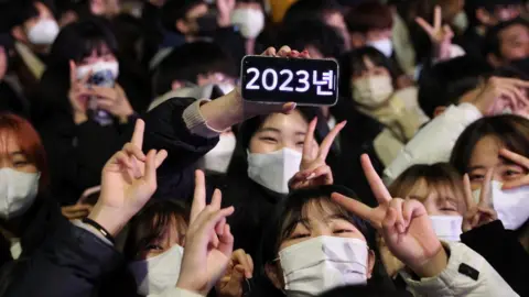 Reuters People gather to celebrate the clocks turning midnight in Seoul, South Korea