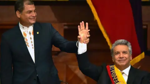 Getty Images Ecuadorean outgoing President Rafael Correa (L) raises Ecuadorean new President Lenin Moreno's hand at the National Assembly in Quito on 24 May 2017, during Mr Moreno's inauguration ceremony